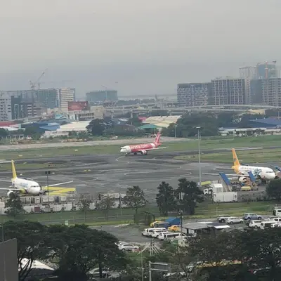 two planes are parked on the runway at an airport at Pasay Condotel near NAIA terminal 3 (3 mins walk in) in Manila