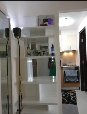 a living room with white shelves in a kitchen at The Florence Condo McKinley Hill in Manila