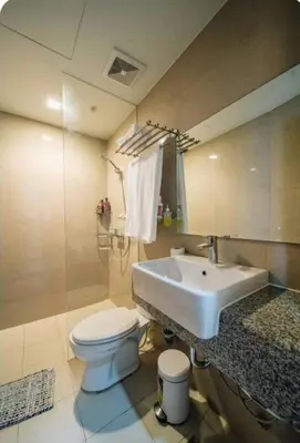a bathroom with a white toilet and a sink at The Florence Condo McKinley Hill in Manila