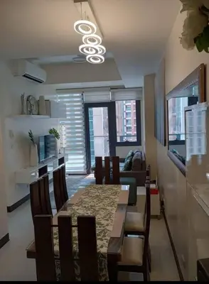 a living room with a dining room table with chairs at The Florence Condo McKinley Hill in Manila