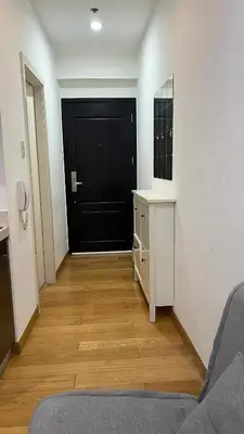 a hallway with a black door and a wooden floor at The Milano Residences in Manila
