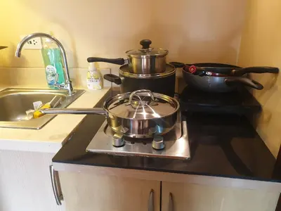 two pots and pans on a stove in a kitchen at Mosaic 10H - Greenbelt Studio in Manila
