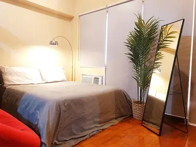 a bedroom with a bed and a potted plant at Mosaic 10H - Greenbelt Studio in Manila