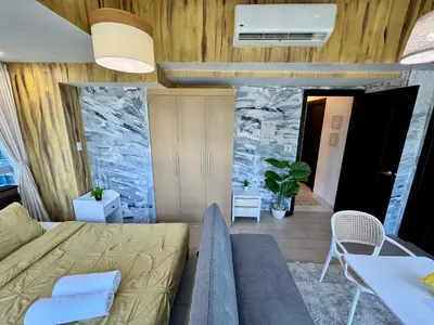 a living room with a bed and a table at Grand Deluxe 3BR with Bathtub in Uptown BGC in Manila