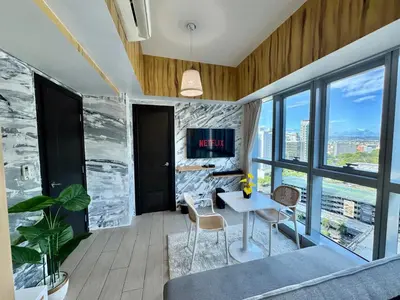 a living room with a table and chairs and a tv at Grand Deluxe 3BR with Bathtub in Uptown BGC in Manila