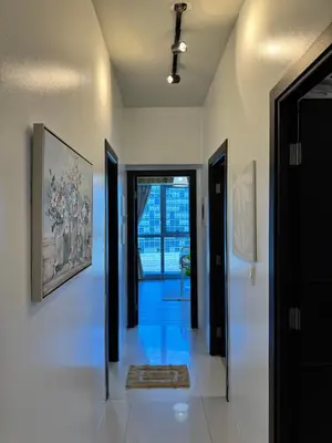a hallway with black doors and a painting on the wall at Grand Deluxe 3BR with Bathtub in Uptown BGC in Manila
