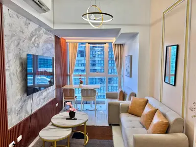 a living room with a couch and a table at Grand Deluxe 3BR with Bathtub in Uptown BGC in Manila