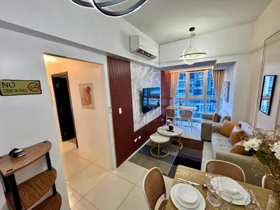 a living room with a couch and a table at Grand Deluxe 3BR with Bathtub in Uptown BGC in Manila