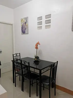 a black table with chairs and a vase with flowers on it at Budget Accomodation in San Pablo City Laguna in Manila