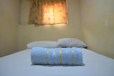 a bed with a blue towel on top of it at Gaius Inn in Manila