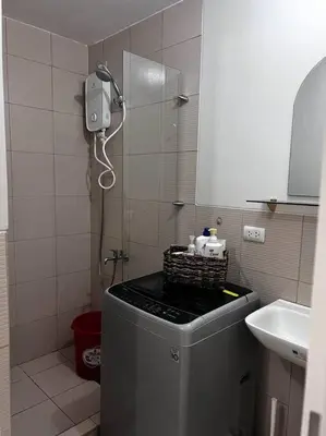 a bathroom with a shower with a phone on the wall at Staycation by JAR - Condo Unit in Manila