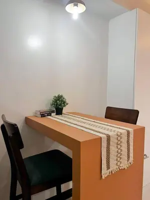 a desk with two chairs and a plant on it at Staycation by JAR - Condo Unit in Manila