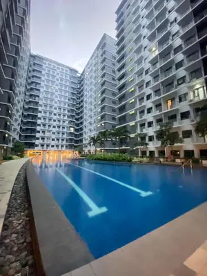 a large swimming pool in front of two tall buildings at Jejo Suite Home Shore 3 Residences Staycation 1 BR Unit Near MOA with Netflix and Prime Video in Manila