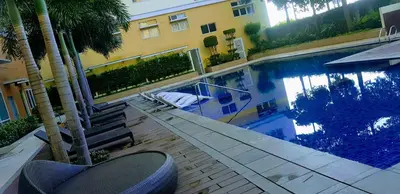 a swimming pool with palm trees next to a building at Hantowah's Crib - Southwoods in San Pedro