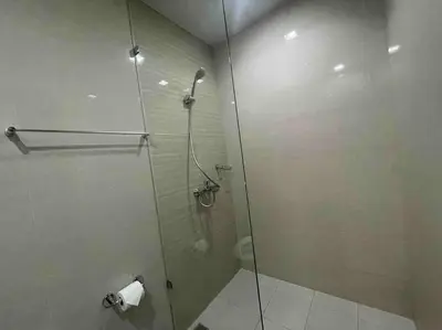 a bathroom with a shower with a glass door at Luxe 1BR w/ Balcony @ Uptown Parksuites in Manila