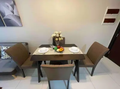 a dining room table with chairs and fruit on it at Luxe 1BR w/ Balcony @ Uptown Parksuites in Manila