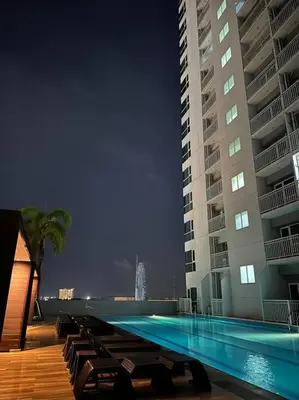 a swimming pool in front of a tall building at Night Blink Staycation and Rentals in Manila