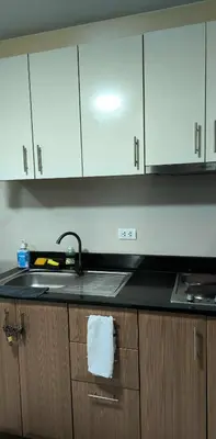 a kitchen counter with a sink and white cabinets at One Palm and Two Palm Tree Villas in Manila