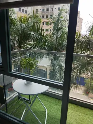a view from a window with a table and palm trees at One Palm and Two Palm Tree Villas in Manila
