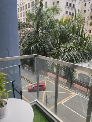 a balcony with a view of a parking lot with a red car at One Palm and Two Palm Tree Villas in Manila