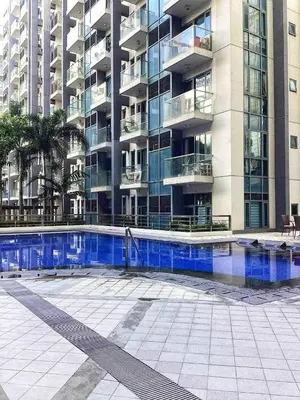 a building with a swimming pool in front of a building at One Palm and Two Palm Tree Villas in Manila