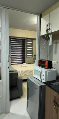 a room with a bedroom with a bed and a tv at Palm Tree Villas in Manila