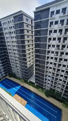two tall apartment buildings with a swimming pool at Blissful Haven Suite Staycation Pasay Metro Manila near SM Mall of Asia Naia Airport Okada in Manila