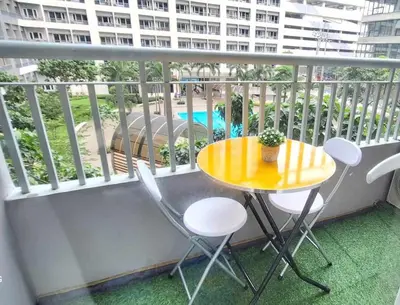 a balcony with a yellow table and chairs on it at Bright and Cozy 1 Bedroom with Balcony Pool View and WiFi in Grace Residences in Manila