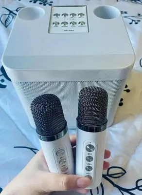 a person holding two microphones in a box at Bright and Cozy 1 Bedroom with Balcony Pool View and WiFi in Grace Residences in Manila