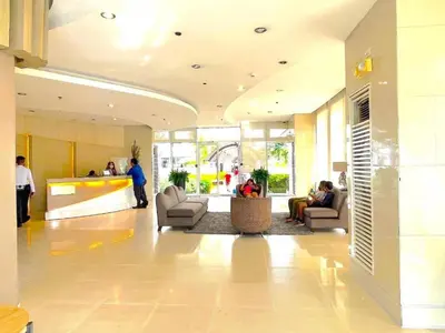 a lobby with people sitting in chairs in a building at Bright and Cozy 1 Bedroom with Balcony Pool View and WiFi in Grace Residences in Manila