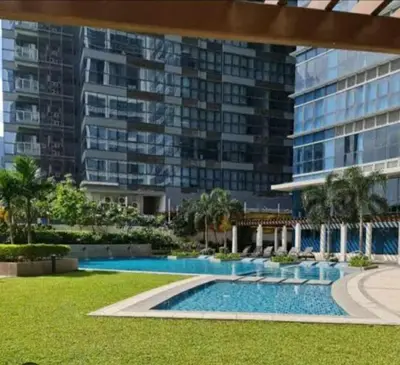 a swimming pool in front of a large building at Uptown Parksuites BGC in Manila