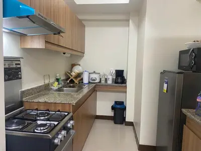 a small kitchen with a stove and a refrigerator at Prisma Residences - Celeste Bldg in Manila