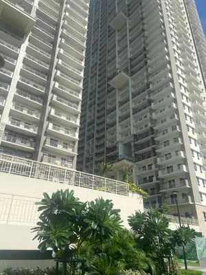 a large building with palm trees in front of it at Prisma Residences - Celeste Bldg in Manila