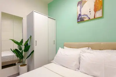 a bedroom with a white bed and a mirror at ClaySky Staycation Cozy Modern 1BR unit near MOA with Netflix & HBO Max in Manila