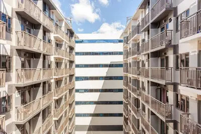 two tall apartment buildings with balconies on them at ClaySky Staycation Cozy Modern 1BR unit near MOA with Netflix & HBO Max in Manila