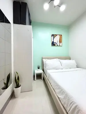 a bedroom with a white bed and a blue wall at ClaySky Staycation Cozy Modern 1BR unit near MOA with Netflix & HBO Max in Manila