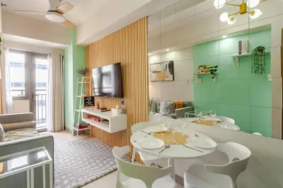 a dining room with a table and a bathroom at ClaySky Staycation Cozy Modern 1BR unit near MOA with Netflix & HBO Max in Manila