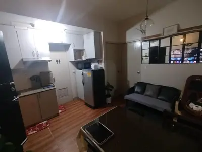 a small living room with a couch and a kitchen at 2-BR COZY condo 200mbpsFiberWiFi/Netflix/pool/WFH in Manila