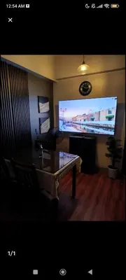 a living room with a large flat screen tv at 2-BR COZY condo 200mbpsFiberWiFi/Netflix/pool/WFH in Manila