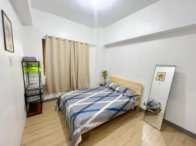 a bedroom with a bed and a mirror in it at One Bedroom condo Unit in Eastwood Libis . Fast free wifi /netflix in Manila