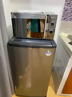 a microwave sitting on top of a refrigerator at One Bedroom condo Unit in Eastwood Libis . Fast free wifi /netflix in Manila
