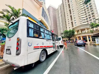 two buses are parked on a city street at One Bedroom condo Unit in Eastwood Libis . Fast free wifi /netflix in Manila