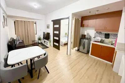 a kitchen and a living room with a table and chairs at One Bedroom condo Unit in Eastwood Libis . Fast free wifi /netflix in Manila