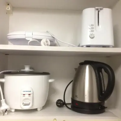 a coffee maker and a toaster on a kitchen shelf at Justcondos at Sea Residences in Manila