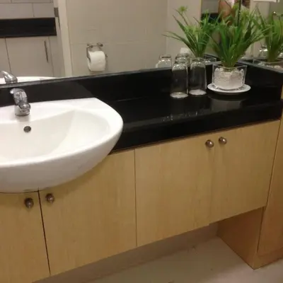 a bathroom with a sink and a black counter at Justcondos at Sea Residences in Manila