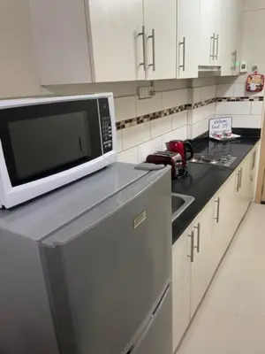 a kitchen with a microwave and a sink at Justcondos at Sea Residences in Manila
