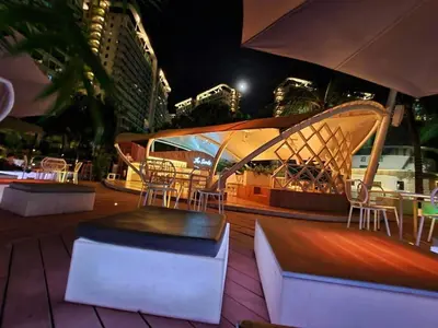 a patio with tables and chairs and an umbrella at Metro Manila Cityscape Charm at Azure Urban Resort Paranaque near NAIA Airport in Manila