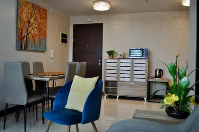 a living room with a blue chair and a table at Casa De Camelina in Manila