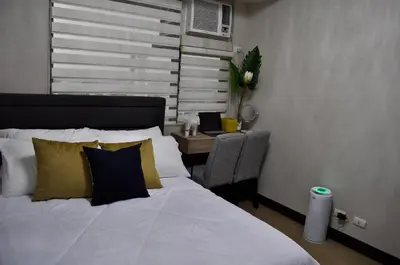 a bedroom with a bed and a chair and a window at Casa De Camelina in Manila