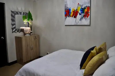 a bedroom with a bed and a painting on the wall at Casa De Camelina in Manila
